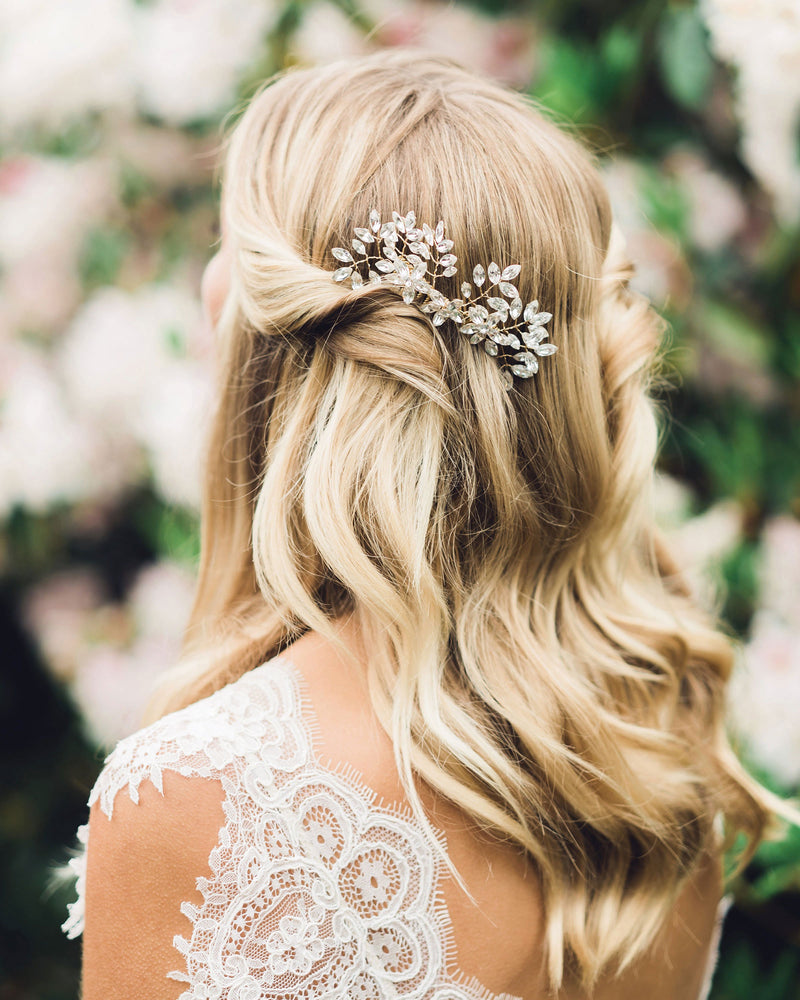 A bride wears her hair down with soft waves with pieces pinned up on both sides; the Everthine Crystal Comb in gold is styled to one side.
