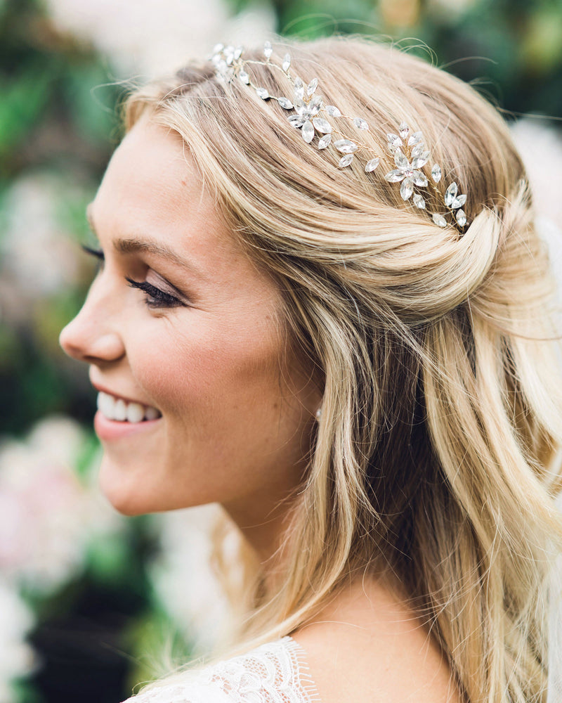 A bride smiles with her hair styled in soft waves. Both sides pinned back. The Everthine Hair Vine in gold is styled into her hair.