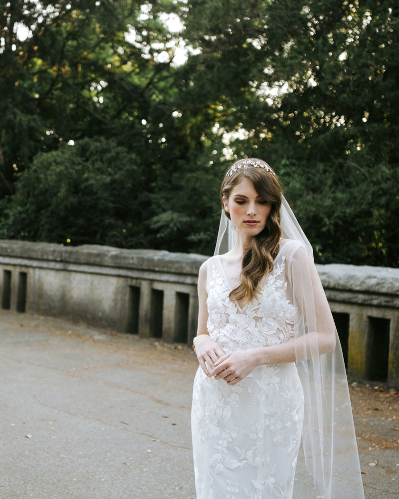 A bride wears the Lily Fingertip Veil with her Made with Love wedding dress.