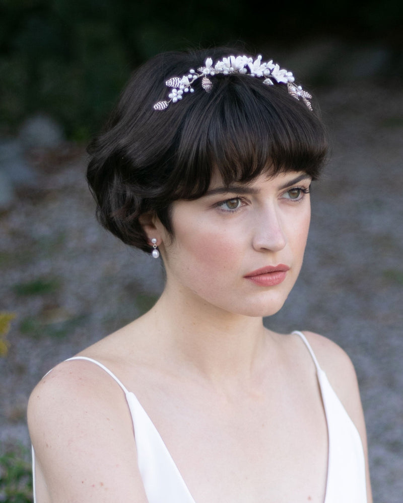 A bride with a pixie hairstyle wears the Lily Floral Crown in silver with blush beaded flowers.