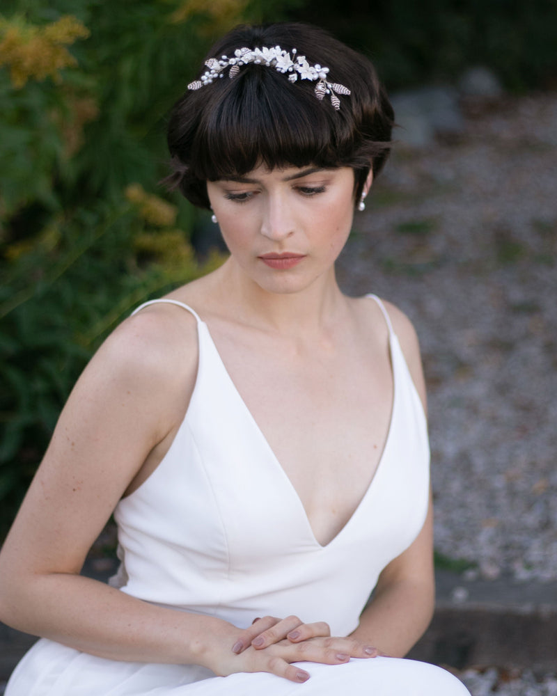 A bride models the Lily Floral Crown in silver with ivory flowers and blush beads.