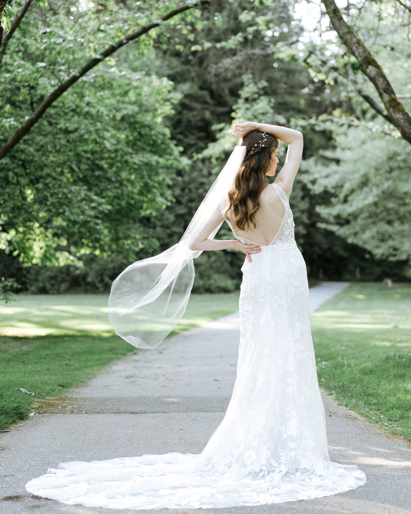A bride wears a waltz or ballet length veil with a hand-cut edge.