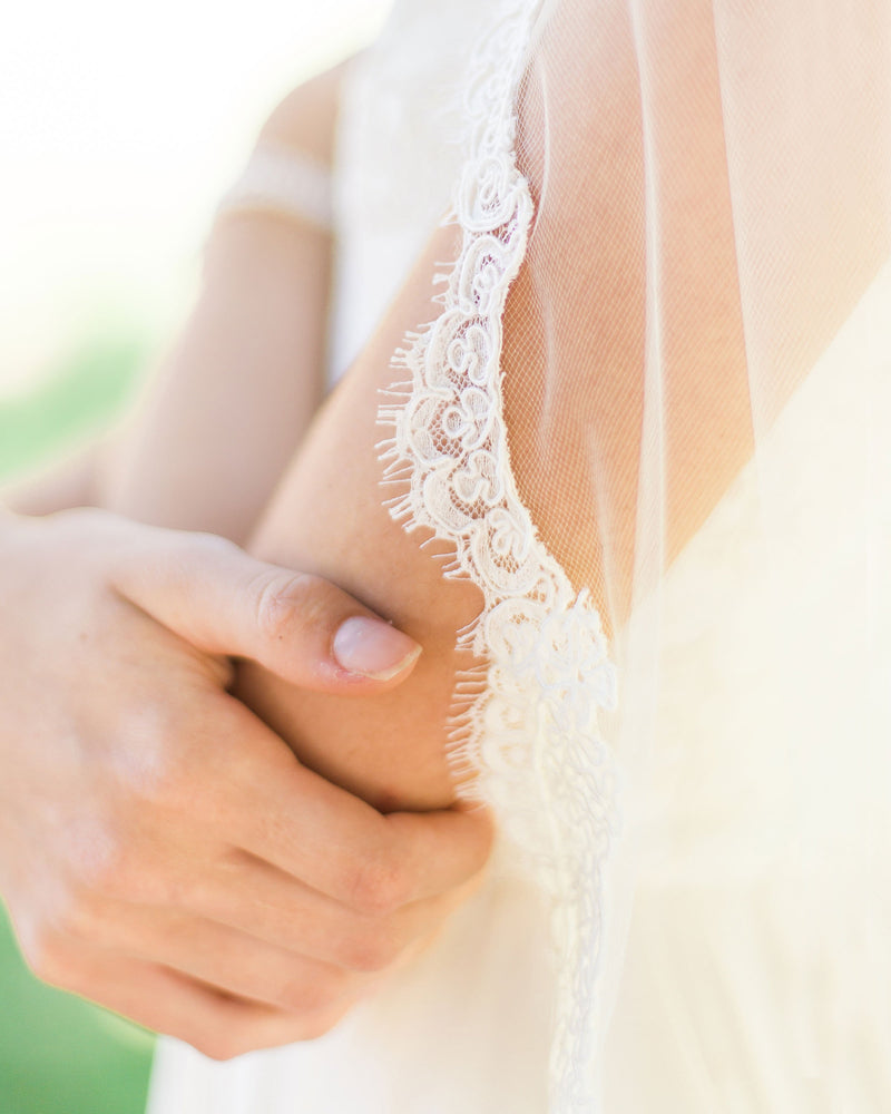 A close on model view of the Alencon lace trim on the Magnolia Veil.