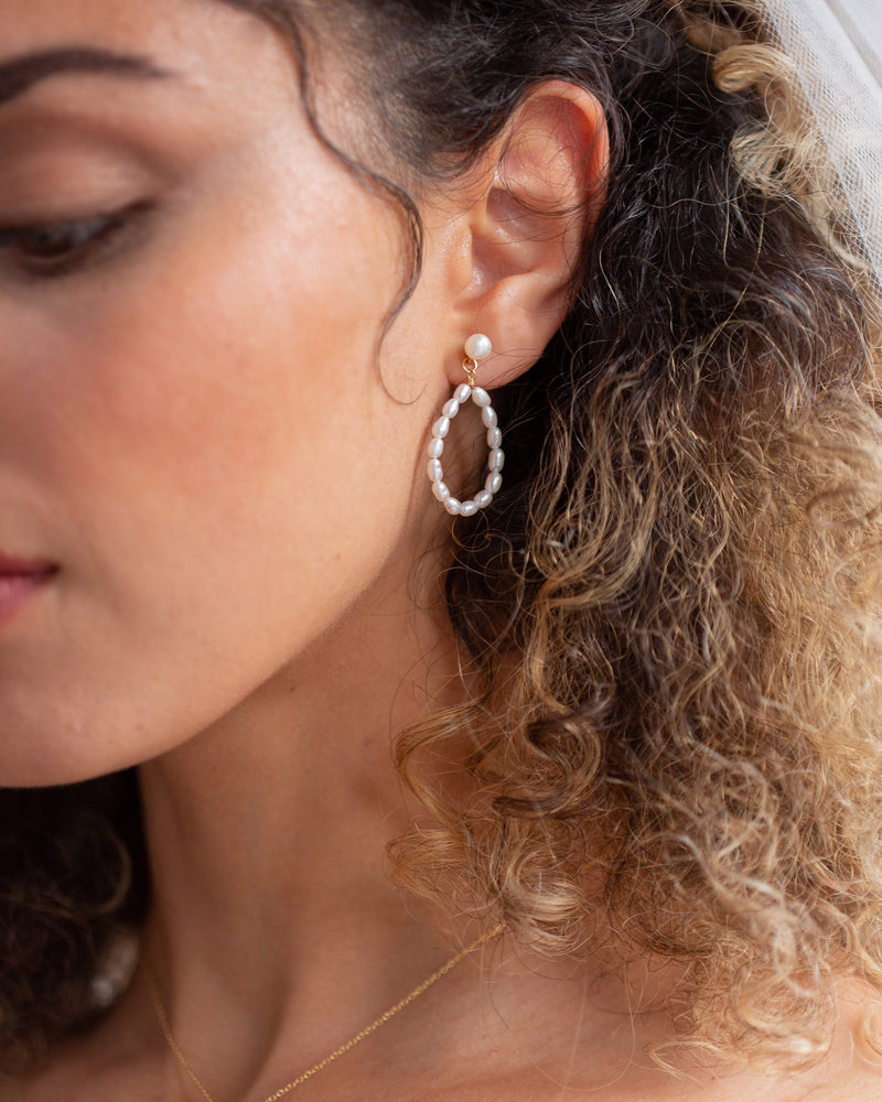 Close model view of the Mira Pearl Earrings in gold.