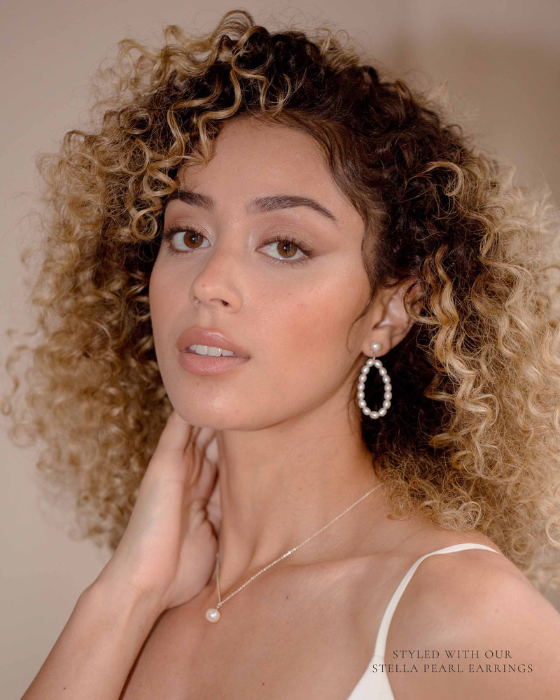 A model wears the Moondrop Pearl Necklace, paired with the Stella Pearl Earrings in silver.