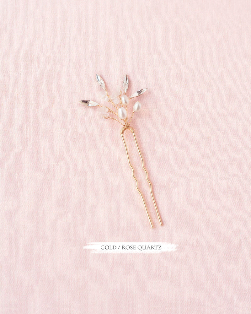 Flatlay of the Sea Mist Bridal Hair Pin in gold with rose quartz, pearls, and crystals.