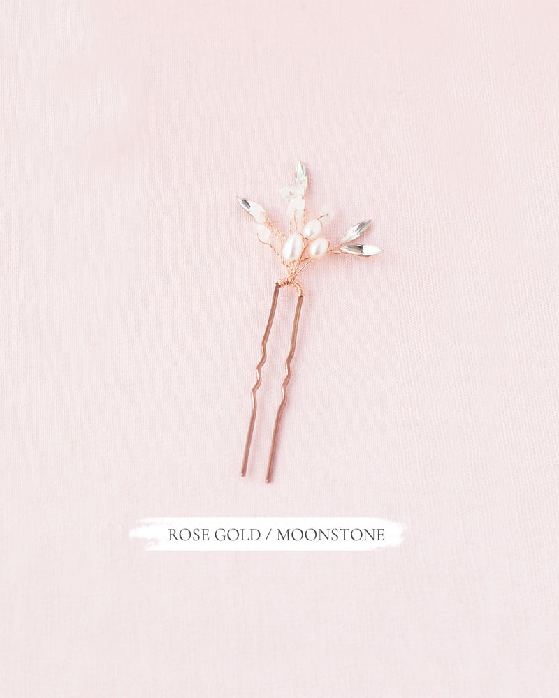 Flatlay of the Sea Mist Bridal Hair Pin in rose gold with moonstone, pearls, and crystals.