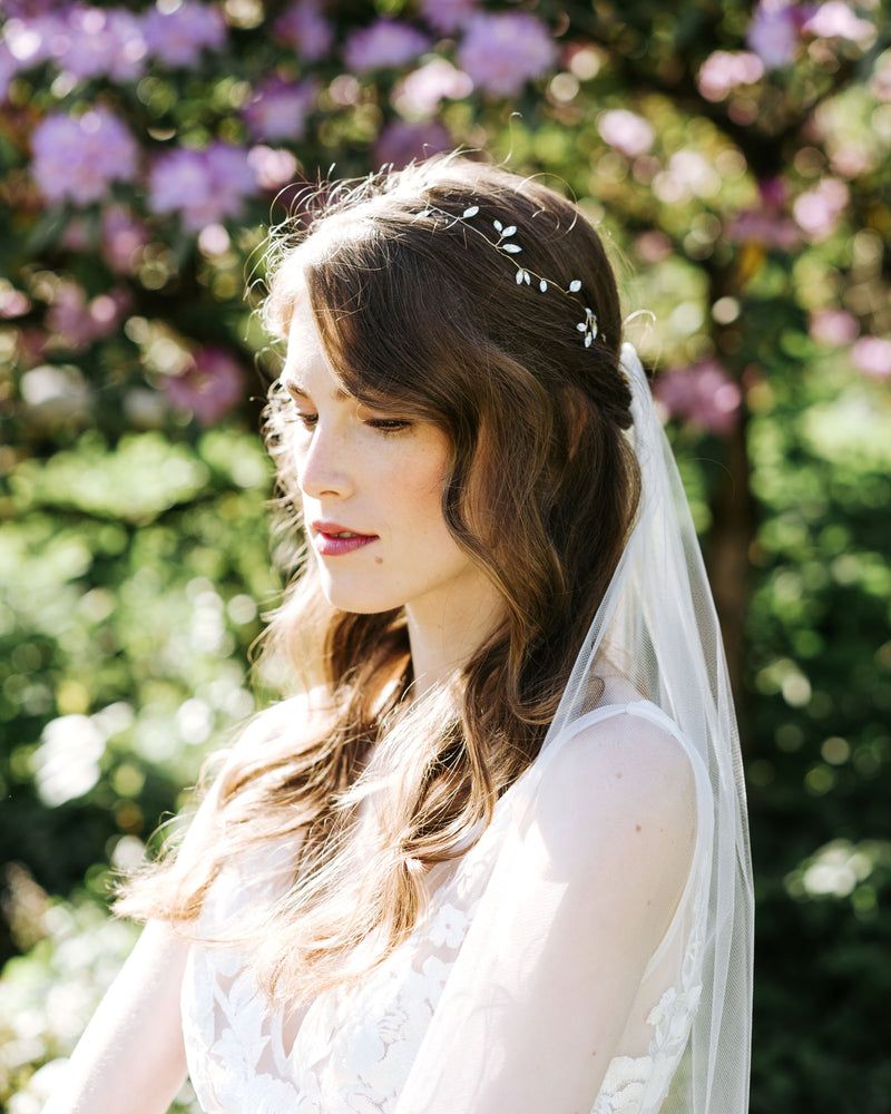 A bride wears the Sparkling crystal hair vine in gold with a simple veil.