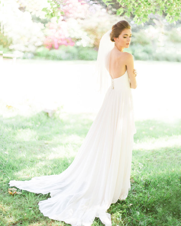 A bride wears a chic short two-layer waist veil.