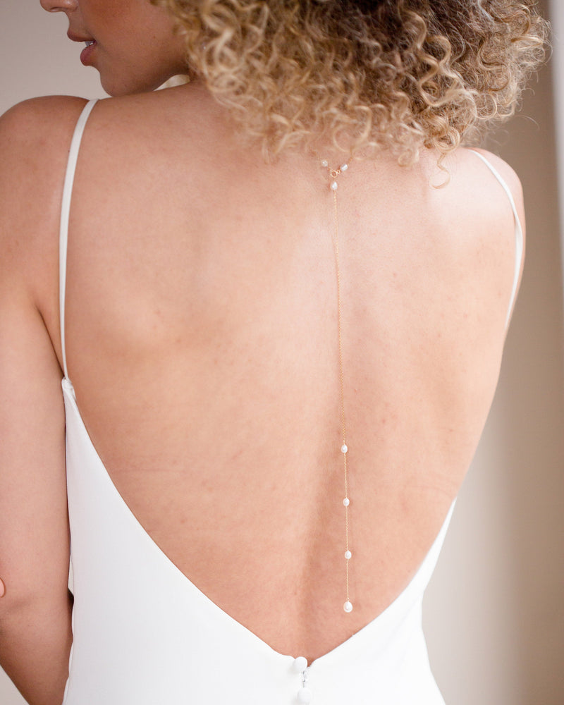 Back view of a model wearing the 11" removable back drape necklace in gold.