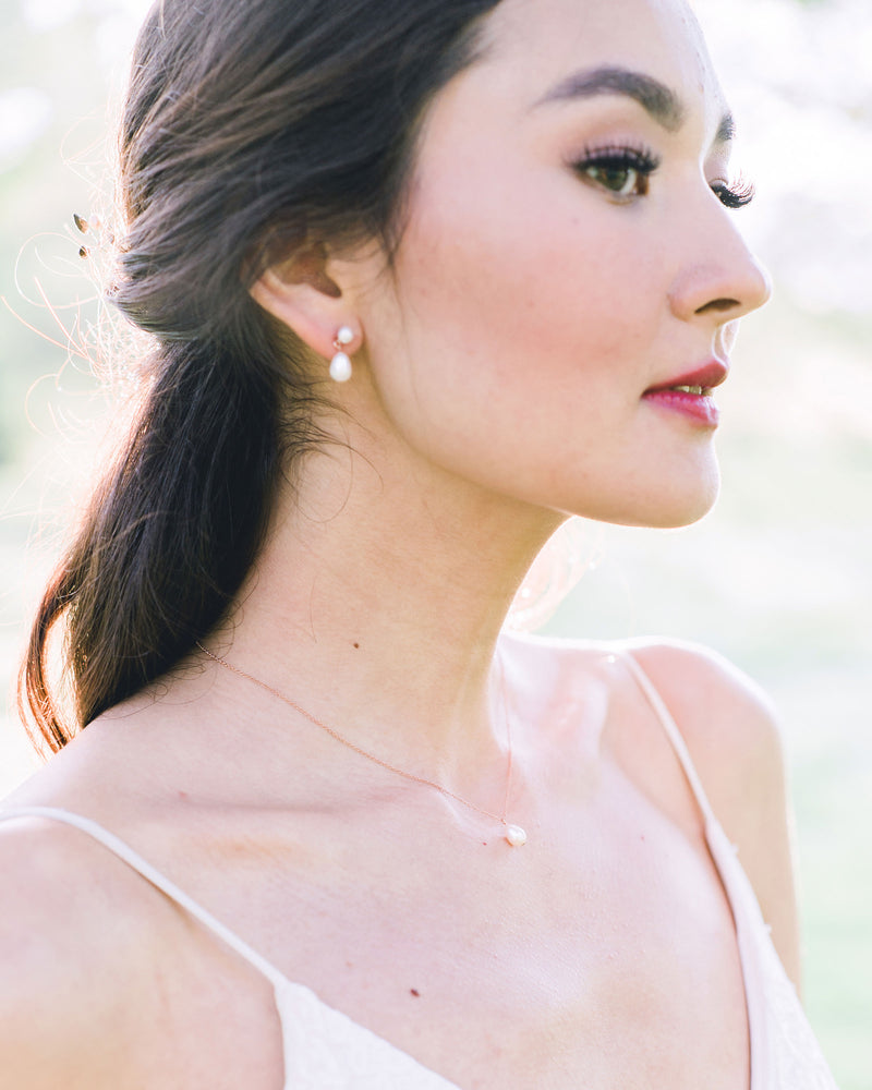 A bride wears a classic Teardrop Pearl Jewellery Set in rose gold.