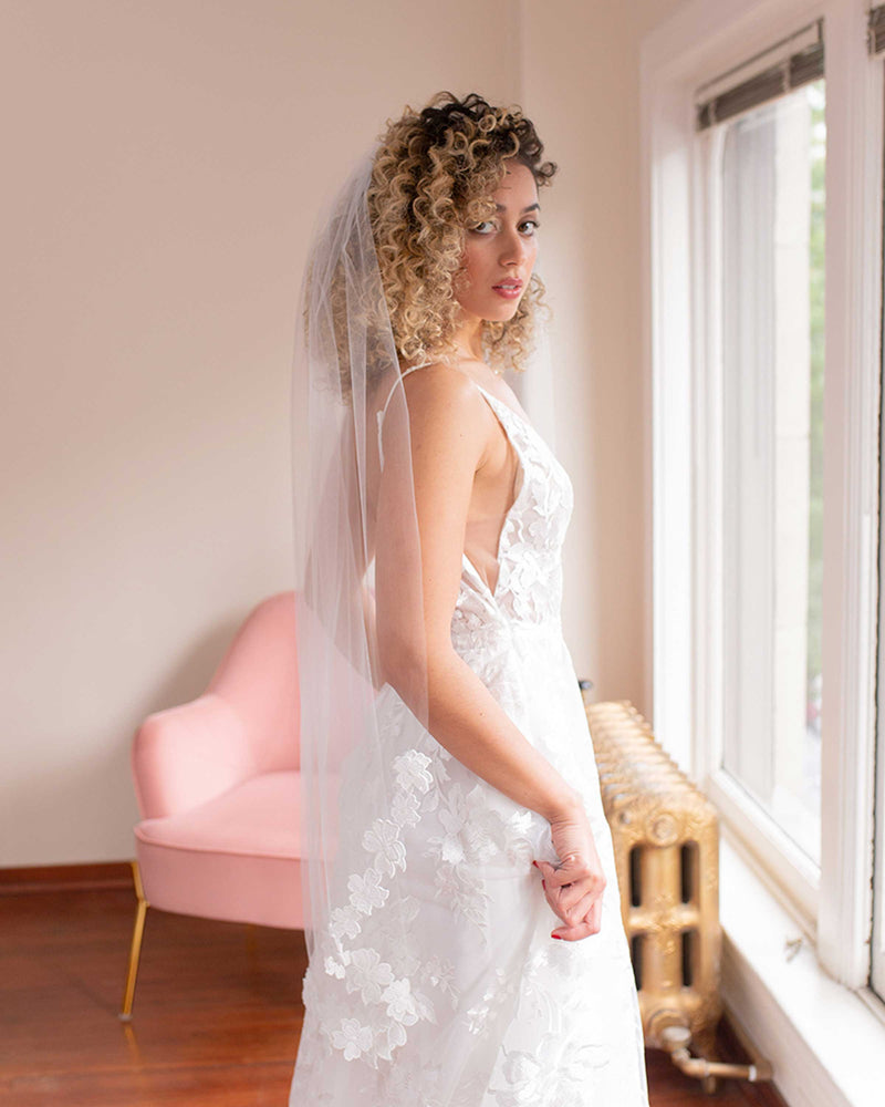 A side view of the Wildflower Floral Lace Veil in fingertip length.