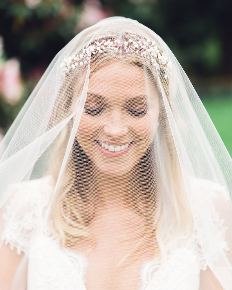 A bride wears the Zahra Horsehair Trim Veil in chapel length, with the blusher worn to the front.